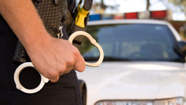 Photo of police officer carrying handcuffs